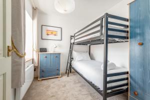 a bedroom with a bunk bed and a blue cabinet at Castle Loft - 2 Bed - Central - Close to castle in St Andrews