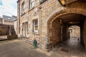 an entrance to a brick building with an archway at Castle Loft - 2 Bed - Central - Close to castle in St Andrews
