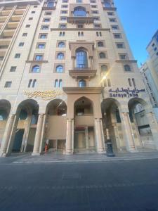 ein hohes Gebäude mit einem Schild an der Vorderseite in der Unterkunft Saraya Harmony Hotel C in Medina