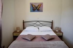 a bed with two pillows and a butterfly picture on the wall at Apartments Renata in Pučišća