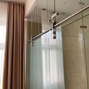 ducha con puerta de cristal y cortina de ducha en Vierzigerhof en Langenlois