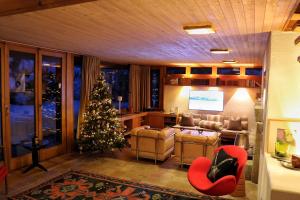 a living room with a christmas tree and a couch at Chalet Morgane in Grindelwald