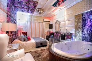 un bagno con vasca e una camera con letto di Hotel Priamos-Αdults Only ad Atene