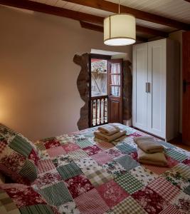a quilt on a bed in a room with a window at La Nozaleda in Infiesto