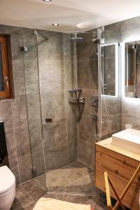 a shower with a glass door in a bathroom at Chalet Morgane in Grindelwald