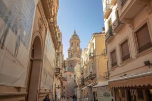 una calle de la ciudad con una torre de reloj en la distancia en C79 - Fabulous Apartment Alcazaba Views, en Málaga