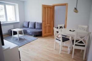 ein Wohnzimmer mit einem Tisch und einem Sofa in der Unterkunft Prie Pušyno in Birštonas