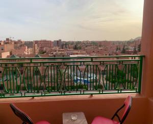 einen Balkon mit Stühlen und Stadtblick in der Unterkunft APPARTEMENT PERLE RARE AU CENTRE DE MARRAKECH in Marrakesch