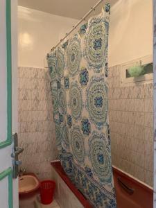 einen Duschvorhang im Bad mit Waschbecken in der Unterkunft APPARTEMENT PERLE RARE AU CENTRE DE MARRAKECH in Marrakesch