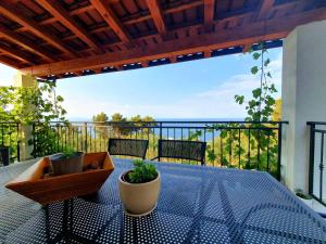 einen Balkon mit einem Tisch und Meerblick in der Unterkunft Apartmani M&S in Sveta Nedelja