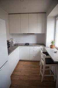 a kitchen with white cabinets and a table and chairs at Prie Pušyno in Birštonas