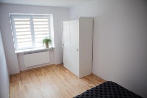 a bedroom with a white cabinet and a window at Prie Pušyno in Birštonas