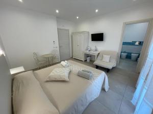 a bedroom with a large bed and a living room at Nure in Stintino