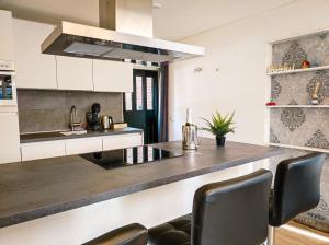 a kitchen with white cabinets and a counter with chairs at Studio with sauna in Amsterdam +11 photos