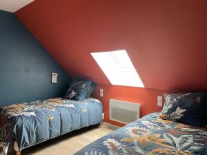 a attic room with two beds and a skylight at Gîtes De Saint Rémy in Villers-Cotterêts