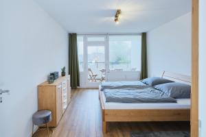 a bedroom with a bed and a large window at Topeingerichtete große 2-Zimmer Wohnung in Immenstaad am Bodensee +13 photos