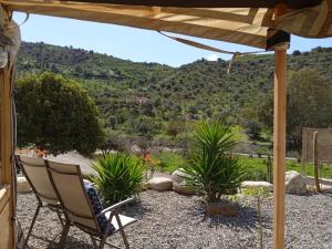 eine Terrasse mit einem Stuhl und Bergblick in der Unterkunft Finca Las Hierbas B&B in Alora
