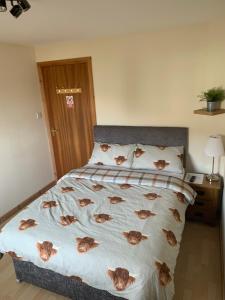 um quarto com uma cama com cães nos lençóis em No 52 - Apartment with Lounge and Dining Area - No kitchen em Ullapool