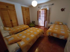 YunqueraにあるCASA PETRA : Bonita casa rural en Yunqueraの黄色と白のシーツが備わる客室のベッド2台