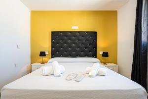 コニル・デ・ラ・フロンテーラにあるApartamentos Turísticos La Boutique del Marのベッドルーム1室(大きな白いベッド1台、スリッパ2枚付)
