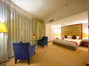Habitación de hotel con cama y silla en Oriental Crystal Hotel, en Kajang