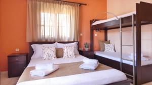 two bunk beds in a room with orange walls at House Chrysoula Mitsokopi in Sarti