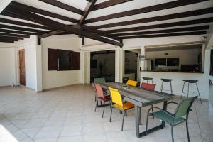 a dining room with a table and colorful chairs at Magnifique villa avec piscine in Sainte-Anne