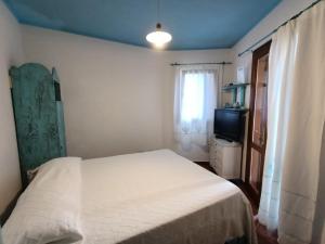 una camera con letto bianco e TV di Lulamax Sardegna a Budoni