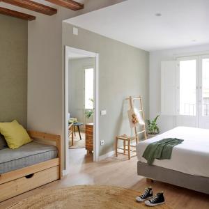
a bedroom with a bed, chair and a window at Eco Boutique Hostal Grau in Barcelona
