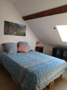 a bedroom with a bed with a blue comforter at Le logis aux digitales in La Croix-aux-Mines