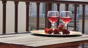 two glasses of wine and roses on a table at House Chrysoula Mitsokopi in Sarti