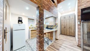 een keuken met een bakstenen muur en een witte koelkast bij LOFT MANHATTAN DE LUX CENTRUM DWORCOWA in Bytom