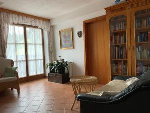 a living room with a couch and chairs and bookcases at Koschak Wirt & Weinbauer in Heimschuh