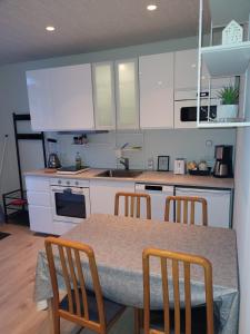 a kitchen with white cabinets and a table and chairs at Cozy studio apartment in central Akureyri. in Akureyri