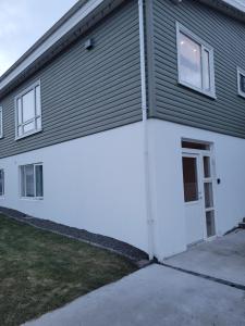 a gray and white building with a door and windows at Cozy studio apartment in central Akureyri. in Akureyri