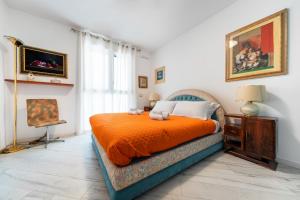 a bedroom with a bed with an orange blanket at UR-NEST Donato Creti in Bologna +30 photos