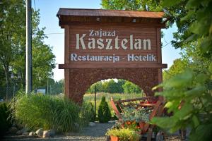 un cartel que lee el restaurante katzka kazakhalam en un jardín en Restauracja Zajazd Kasztelan, en Krosno