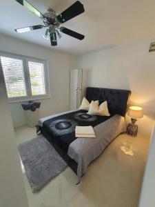 a bedroom with a black bed with a ceiling fan at Apartman Renata & Apartman Maja in Trogir +44 photos