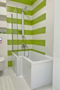W łazience znajduje się wanna w odcieniach zieleni i bieli. w obiekcie Capital Towers - Apartament Pop-art z widokiem na rzekę w mieście Rzeszów