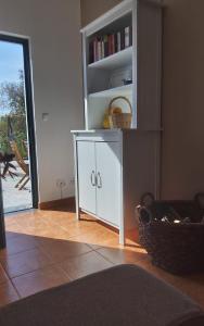 a white cabinet in a room with a book shelf at Casa do Brejão 1 bedroom cottage in Odemira