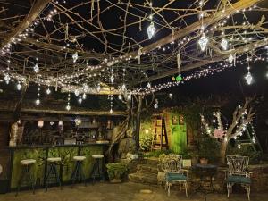 a room with lights and chairs and a bar at Feggaropetra Inn Magic Mountain House in Palaios Panteleimon