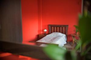 a red bedroom with a bed and two tables at Restauracja Zajazd Kasztelan in Krosno