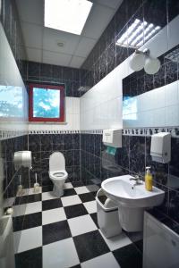 a bathroom with a black and white checkered floor at Restauracja Zajazd Kasztelan in Krosno