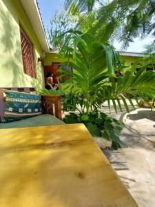a wooden table in front of a house with plants at Amarrosi Lion - Studio terrace Apartment ,Mtwapa in Mtwapa