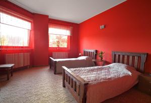 a bedroom with two beds and red walls at Restauracja Zajazd Kasztelan in Krosno