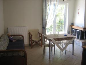 a living room with a table and a child sitting on a couch at Filoxenia in Levidi