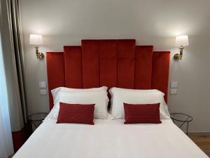 1 cama blanca grande con 2 almohadas rojas en Corte dei Sogni Boutique Hotel & spa, en Florencia
