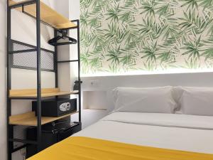 1 dormitorio con litera y colcha amarilla en Nanit Rooms Ibiza Hostal en Santa Eulalia del Río