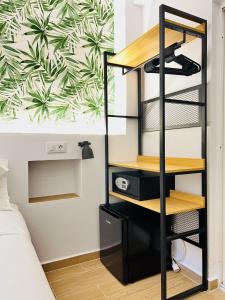 a bedroom with a black shelving unit and a wall with a mural at Nanit Rooms Ibiza Hostal in Santa Eularia des Riu