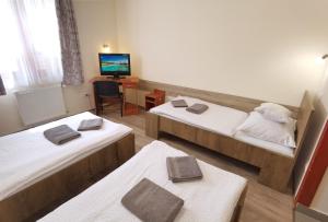 A bed or beds in a room at Kamilla Panzió és Rendezvényház